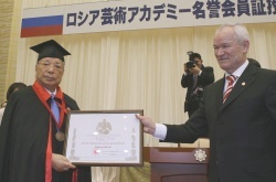 Mr. Fatkulin (right) presents the certificate to Mr. Ikeda (left)