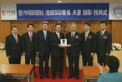 SGI-Korea General Director Yeo Sang Rak (4th from left) receives plaque on behalf of the SGI President and Mrs. Ikeda from CEO Chung (3rd from right)