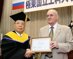 Dr. Turmov (right) presents the certificate to Mr. Ikeda