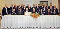 President Facci (seated 4th from right) entrusts the certificate to Mr. Taguchi (seated 5th from right)