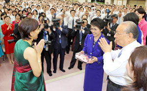 Mr. and Mrs. Ikeda present a corsage to an SGI member from India attending the meeting. (February 6, 2008)