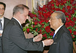 Ambassador Bely (left) pins the Order of Friendship on Mr. Ikeda's (right) lapel