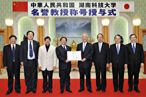 HNUST President Tian (4th from left) entrusts the honorary degree certificate for Mr. Ikeda to SU President Yamamoto (4th from right). Other HNUST delegates, from left to right: Wang Weijun, director, School of Energy and Safety Engineering; Zhang Yadong, director, External Communications; and Vice President Cao Chenzhong