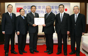 Director Xie (3rd from left) presents the certificate of honorary advisor for Mr. Ikeda to Min-On President Kobayashi (3rd from right)