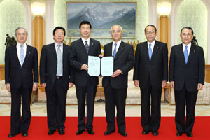 Hebei University President Wang (third from left) presents Soka University President Yamamoto with the honorary professorship certificate for Mr. Ikeda