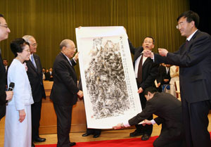 Yan'an University representatives present Mr. and Mrs. Ikeda with a Chinese brush painting titled 