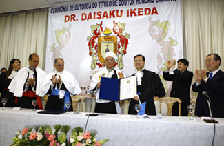 Rector Oliveira (fourth from left) entrusts Mr. Ikeda's honorary certificate to his son, Hiromasa Ikeda (3rd from right)