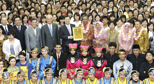 Rector Sunaryo (center, with lei) and Hiromasa Ikeda (to his left) holding the certificate
